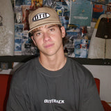 Person wearing a cap and t-shirt with visible branding in an indoor setting.