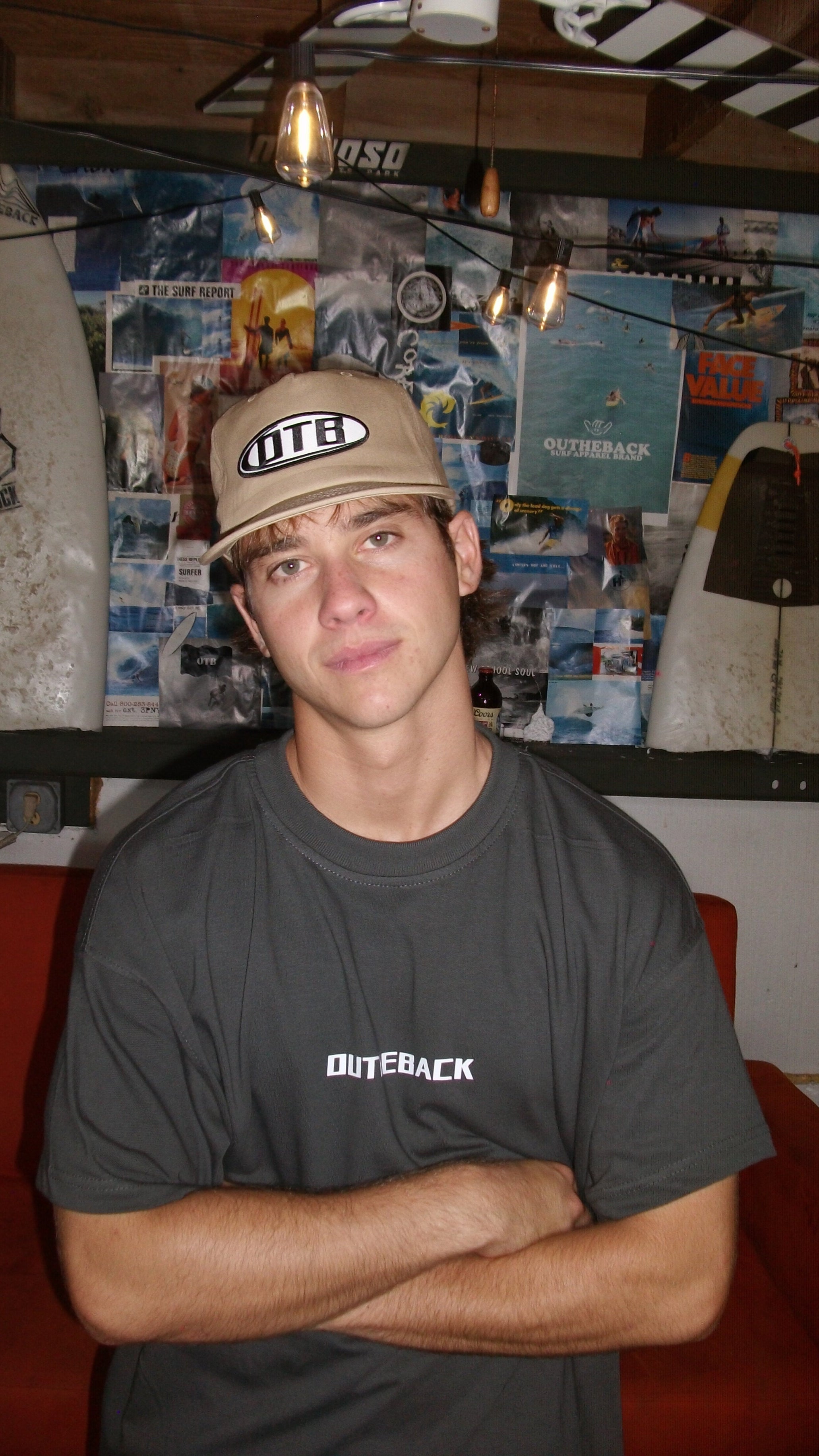 Person wearing a cap and t-shirt with visible branding in an indoor setting.